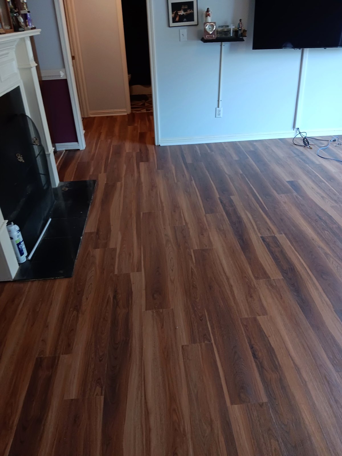 Newly installed wood-look flooring in a living room with a fireplace